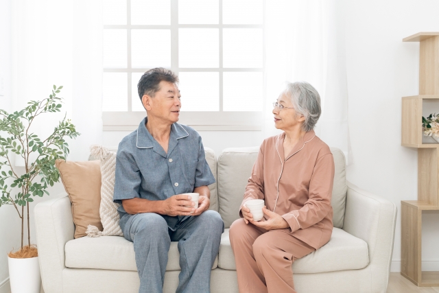 リビングで会話を楽しむ高齢の夫婦