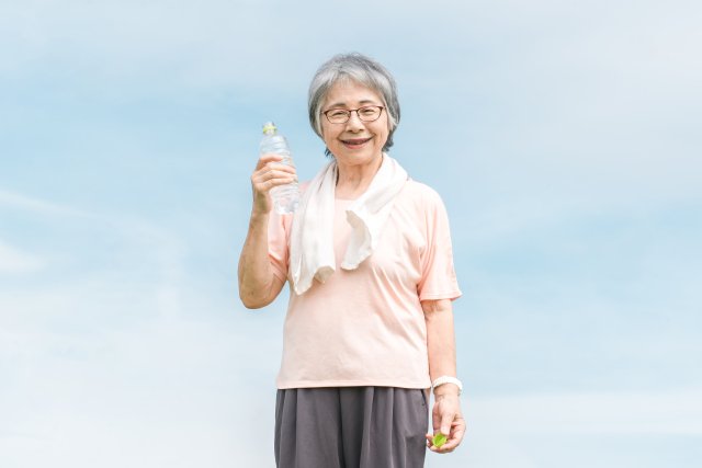 青空の下でシャボン玉を吹く高齢女性