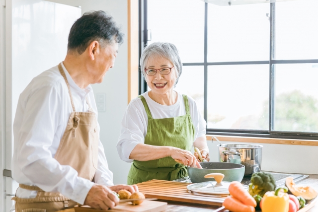 キッチンで料理を楽しむシニア夫婦