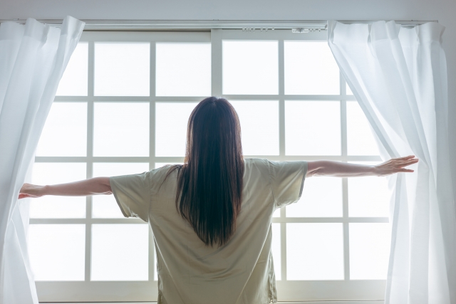 朝の光を迎える女性の後姿
